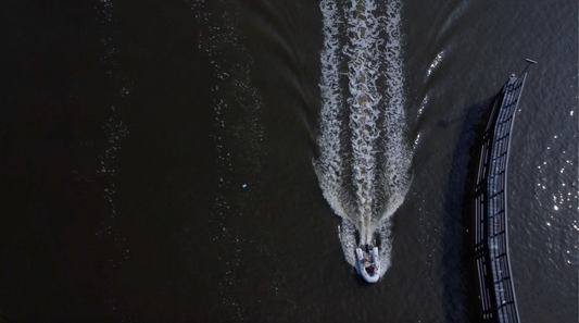 Two Dinghies Cutting Through Polluted Waters